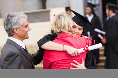 Female graduate hugging her family after graduation